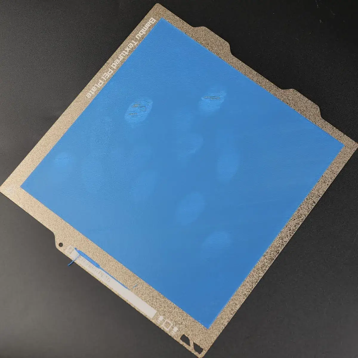 Placa de impressão 3D com marcas de dedo onde o material não aderiu